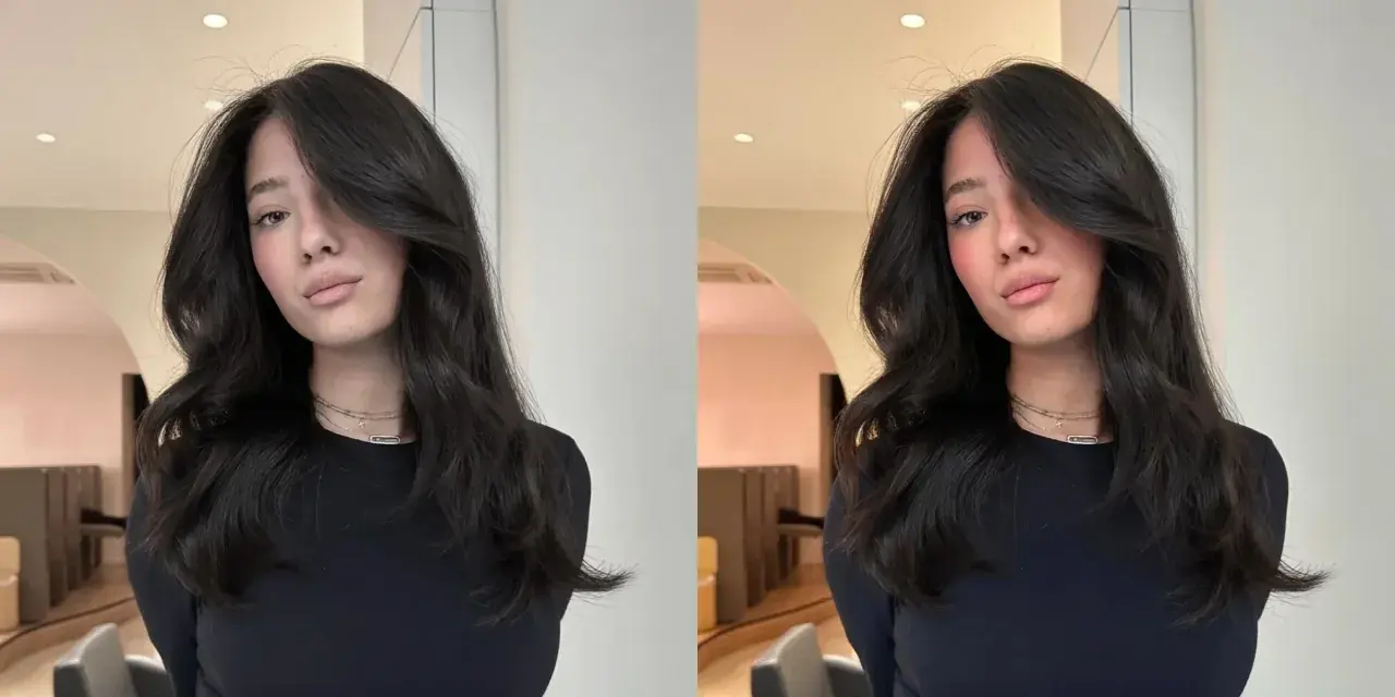 Une jeune femme aux cheveux bruns et brillants, pose avec un sourire subtil. Elle porte un col roulé noir et des colliers fins. On se demande combien de temps dure un gloss cheveux pour obtenir un tel éclat.