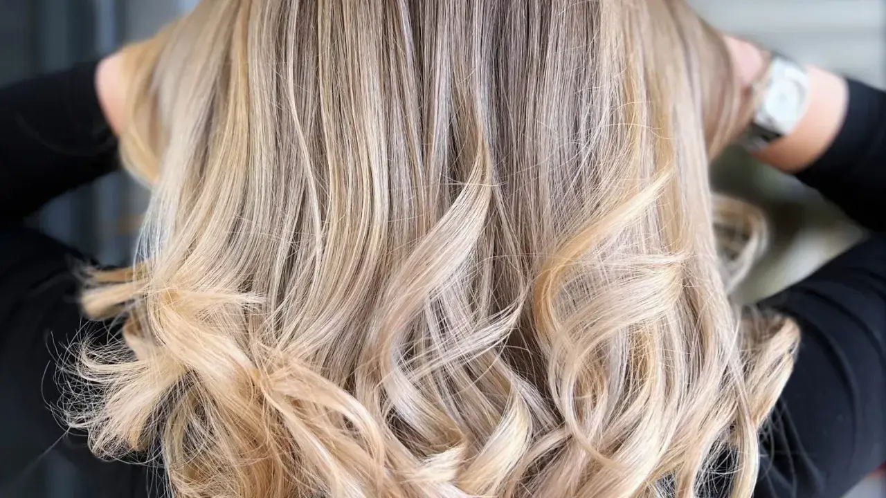 Chevelure ondulée d'un blond polaire lumineux, aux reflets subtils et naturels.