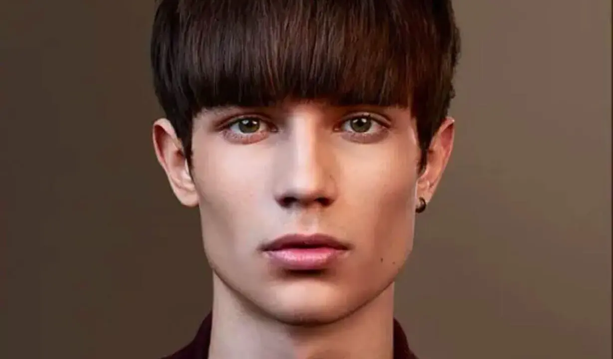 Un jeune homme au regard intense arbore une coupe au bol homme audacieuse, encadrant son visage aux traits fins.