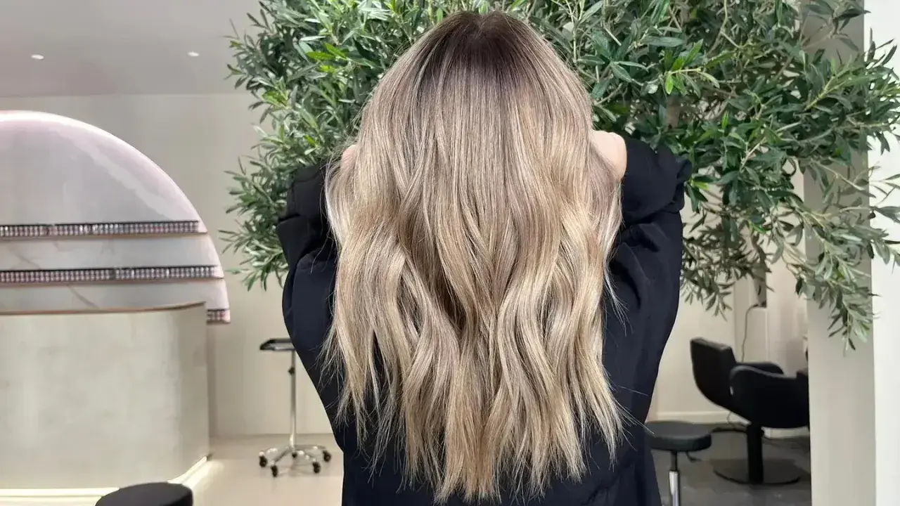 Magnifique coloration après henné, des reflets blonds naturels et lumineux sur une chevelure ondulée.