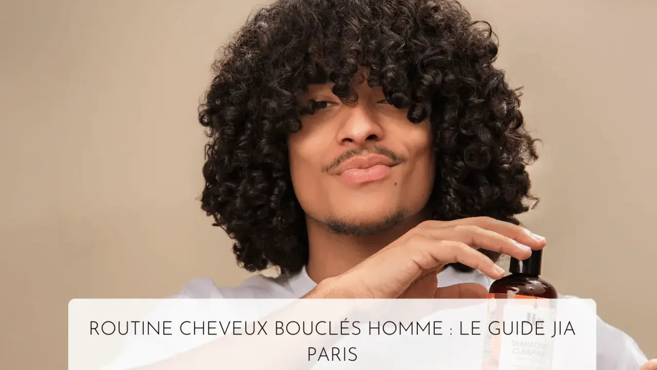 Un homme aux cheveux bouclés tient un flacon de shampoing, parfait pour l'hydratation cheveux bouclés.
