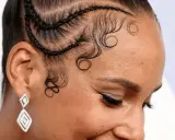 Coiffure avec des tresses et des boucles élégantes sur la hairline cheveux bouclés. Boucles artistiques encadrant le visage.