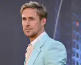 Ryan Gosling, avec une coupe homme cheveux fins, porte un costume bleu pastel et une chemise à rayures.