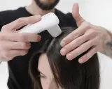 Application d'un appareil sur le cuir chevelu, peut-être pour évaluer les effets secondaires de Furterer Triphasic Progressive.