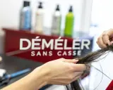 Une main démêle des cheveux emmêlés, espérant qu'il n'y ait pas un énorme nœud dans les cheveux.