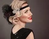 Coiffure année 20 cheveux long, avec bandeau orné de plumes et de strass. Une touche glamour pour une soirée chic.