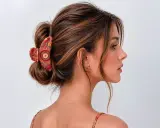 Coiffure chic avec une pince à cheveux ornée de motifs ethniques, retenant un chignon flou.