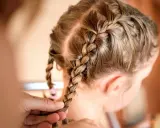 Une coiffure petite fille tresse facile, avec deux nattes bien serrées sur le dessus de la tête.