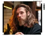 Un homme avec une barbe et de longs cheveux ondulés, parfait pour un projet cheveux long homme.