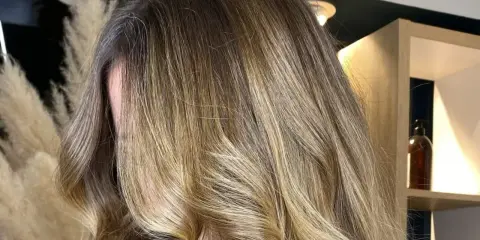 Chevelure longue et ondulée avec un magnifique effet soleil, des reflets blonds dorés qui illuminent la masse.