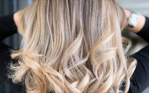 Chevelure ondulée d'un blond polaire lumineux, aux reflets subtils et naturels.