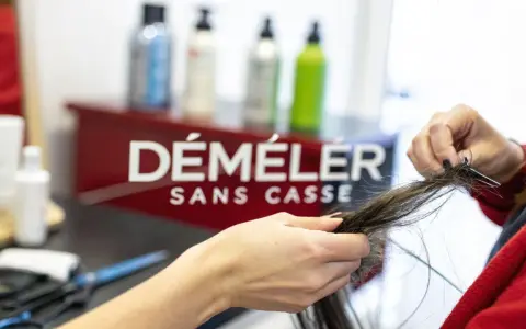 Une main démêle des cheveux emmêlés, espérant qu'il n'y ait pas un énorme nœud dans les cheveux.