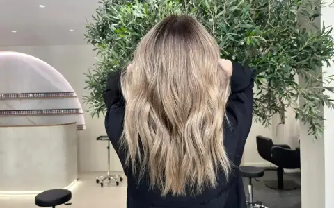 Magnifique coloration après henné, des reflets blonds naturels et lumineux sur une chevelure ondulée.