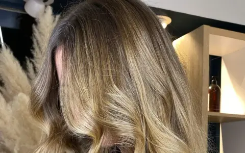 Chevelure longue et ondulée avec un magnifique effet soleil, des reflets blonds dorés qui illuminent la masse.