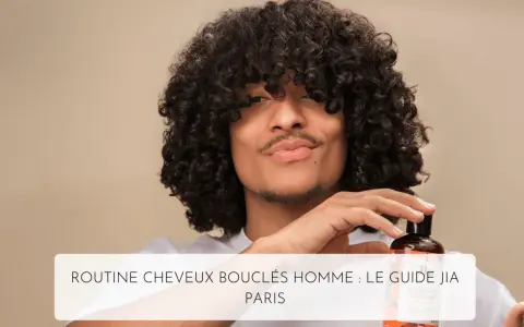 Un homme aux cheveux bouclés tient un flacon de shampoing, parfait pour l'hydratation cheveux bouclés.