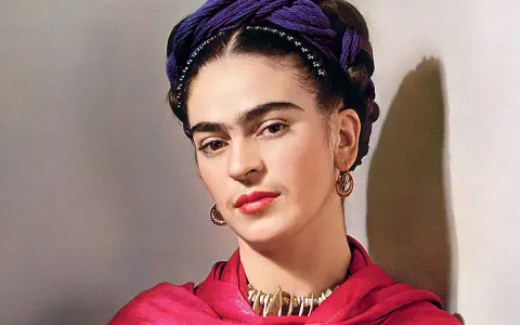 Portrait de Frida Kahlo avec sa célèbre coiffure torsadée violette, un foulard rouge vif et des bijoux ethniques.