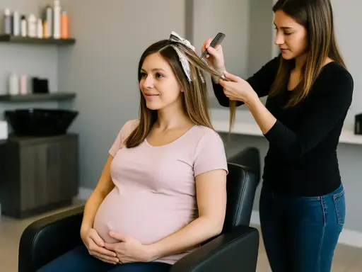 Une femme enceinte profite d'un balayage chez le coiffeur. Elle tient son ventre avec un sourire doux.