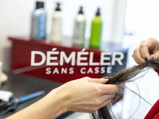 Une main démêle des cheveux emmêlés, espérant qu'il n'y ait pas un énorme nœud dans les cheveux.