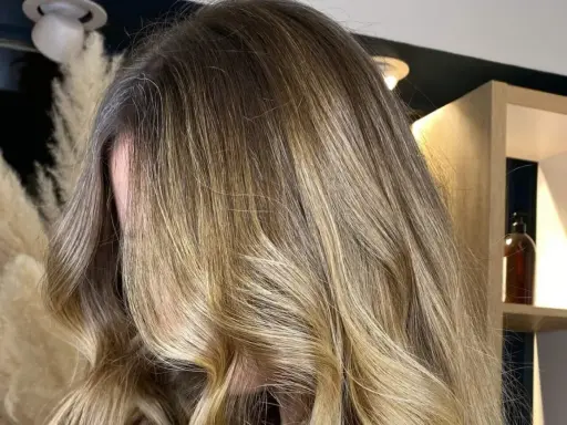 Chevelure longue et ondulée avec un magnifique effet soleil, des reflets blonds dorés qui illuminent la masse.
