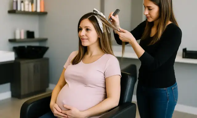 Une femme enceinte profite d'un balayage chez le coiffeur. Elle tient son ventre avec un sourire doux.