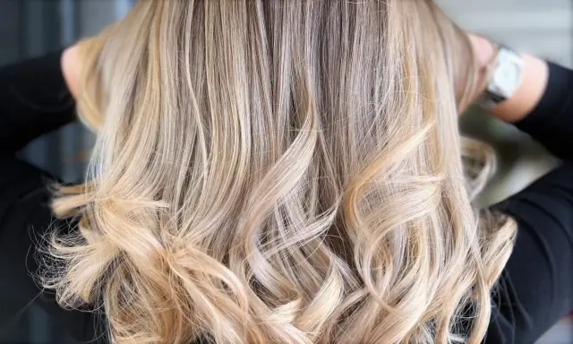 Chevelure ondulée d'un blond polaire lumineux, aux reflets subtils et naturels.
