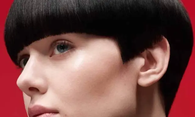 Un visage féminin avec une coupe de cheveux audacieuse, un carré court et arrondi. Ce nom de coupe de cheveux femme met en valeur le regard.