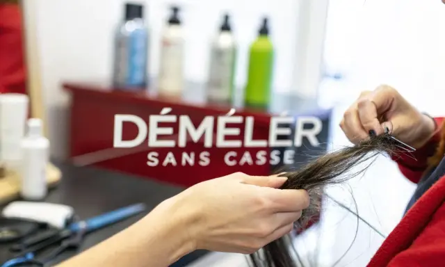 Une main démêle des cheveux emmêlés, espérant qu'il n'y ait pas un énorme nœud dans les cheveux.