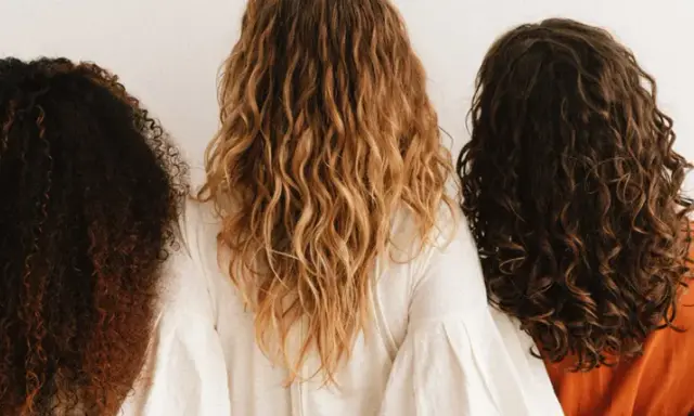 Trois femmes montrent leurs cheveux bouclés abîmés, de différentes couleurs et textures, sur fond blanc.