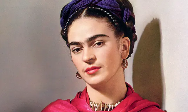 Portrait de Frida Kahlo avec sa célèbre coiffure torsadée violette, un foulard rouge vif et des bijoux ethniques.