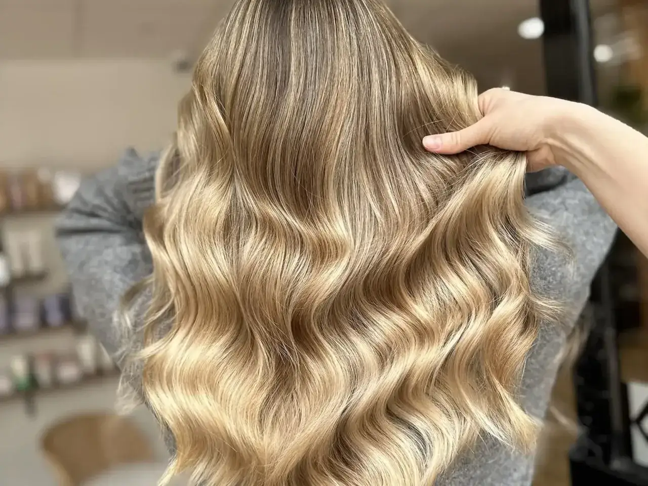 Une chevelure ondulée aux reflets dorés, un blond subtil qui joue avec la lumière. Un style différent blond pour un look naturel.