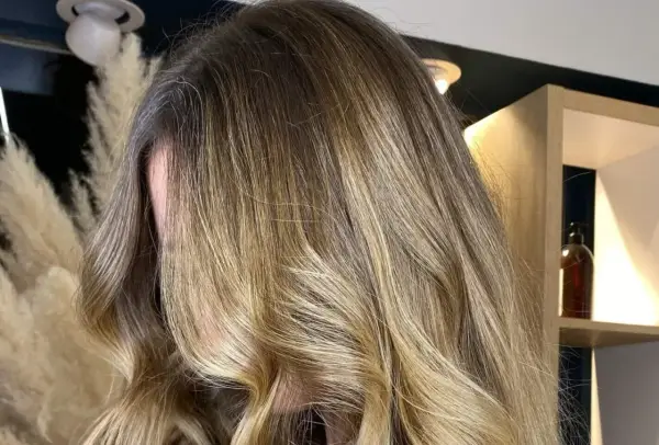Chevelure longue et ondulée avec un magnifique effet soleil, des reflets blonds dorés qui illuminent la masse.